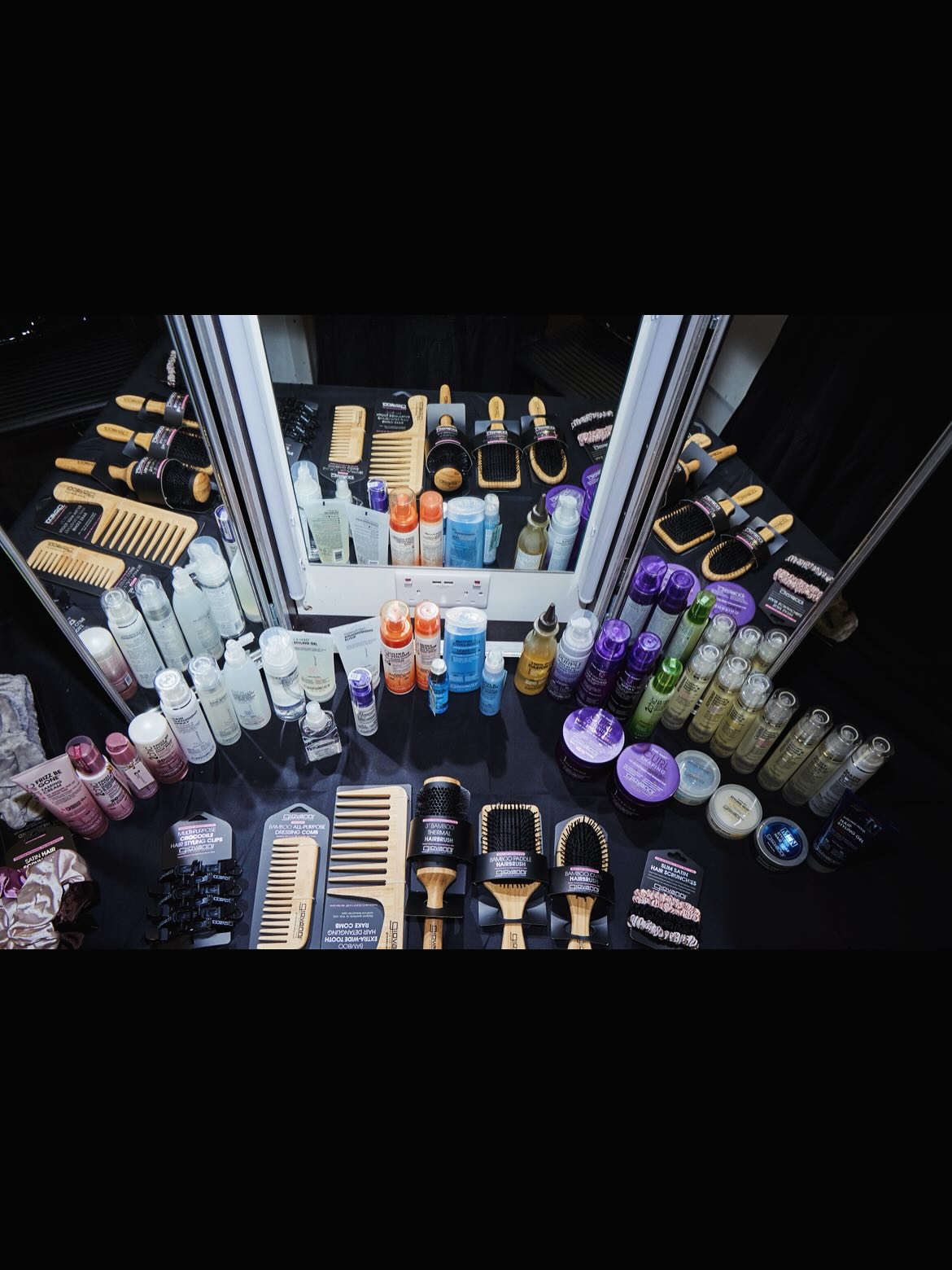 Collection of Giovanni hair care products and tools on a black surface