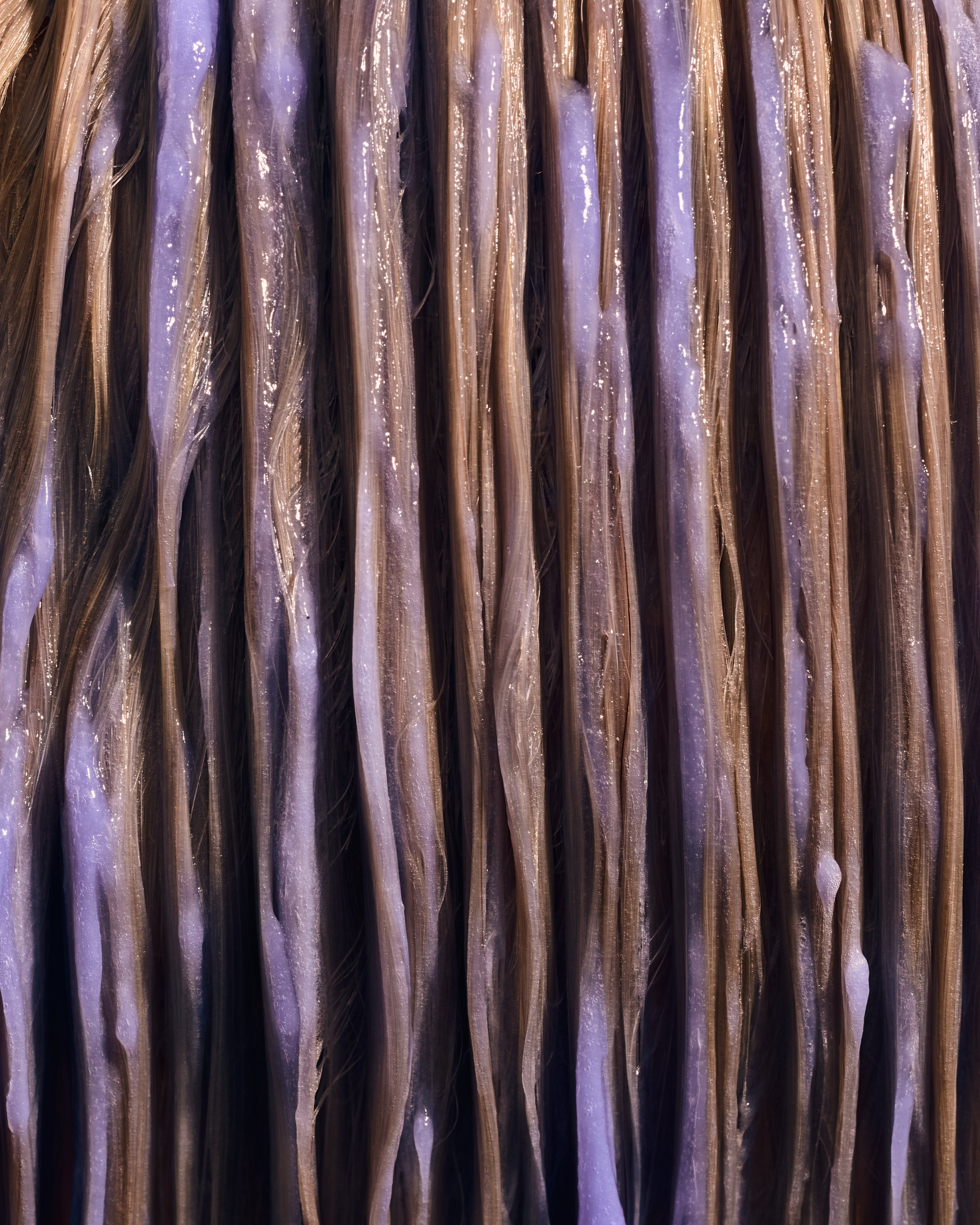 Image of Purple Conditioner combed through blonde hair