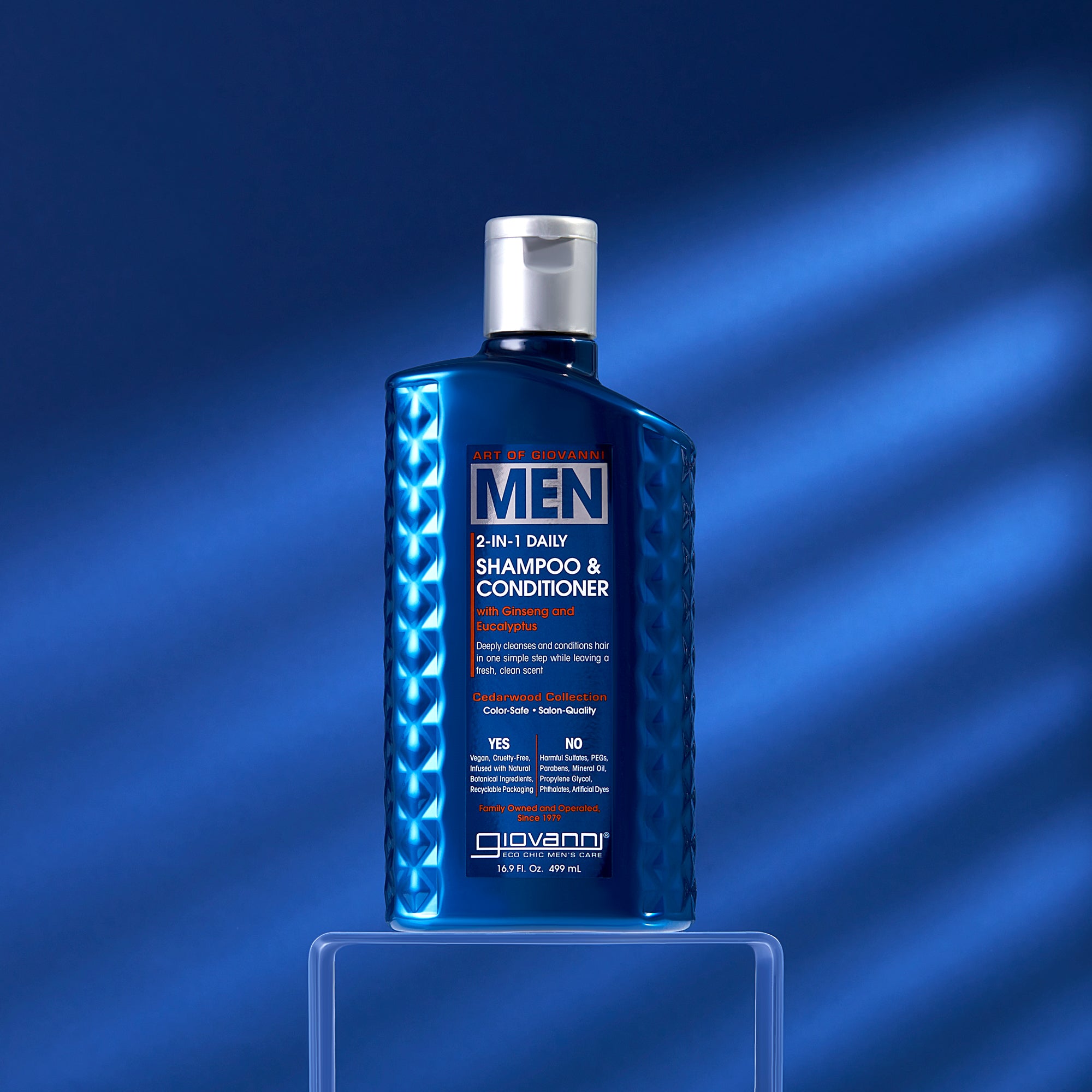 A blue bottle of Giovanni Cosmetics MEN 2-in-1 Daily Shampoo & Conditioner with Ginseng & Eucalyptus sits on a clear stand against a blue background, its front label visible amid soft shadows.