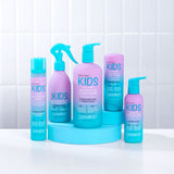 Five pastel blue and purple Giovanni Cosmetics ECO CHIC® KIDS CURL ACTIVATOR SPRAY bottles, ideal for curly hair and moisture retention, sit on a blue stand with other Giovanni Kids products against a white tiled background.